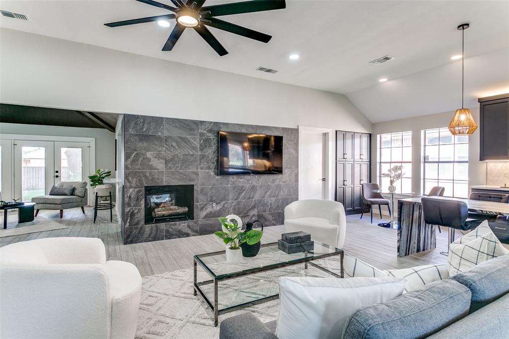 3913 Bobbin Lane Addison, TX 75001 - Photo 10 of 23 Living room featuring lofted ceiling, plenty of natural light, wood finished floors, a tile fireplace, and recessed lighting
