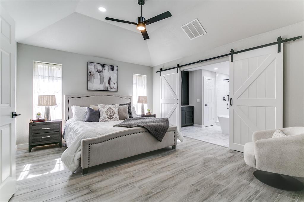 3913 Bobbin Lane Addison, TX 75001 - Photo 14 of 23 Bedroom with a barn door, multiple windows, ensuite bathroom, recessed lighting, and light wood-style flooring