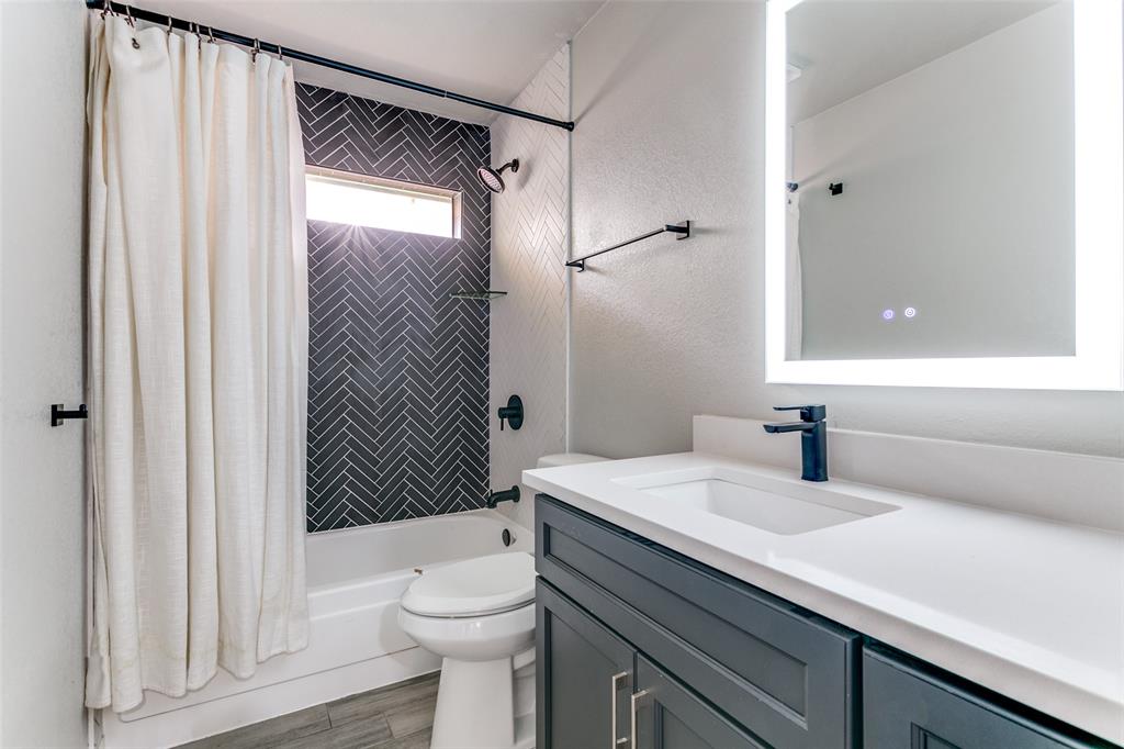 3913 Bobbin Lane Addison, TX 75001 - Photo 19 of 23 Bathroom featuring vanity, shower / bathtub combination with curtain, and light wood-style floors
