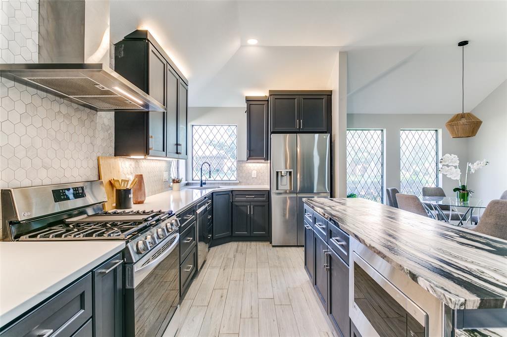 3913 Bobbin Lane Addison, TX 75001 - Photo 8 of 23 Kitchen with stainless steel appliances, decorative backsplash, lofted ceiling, pendant lighting, and wooden counters