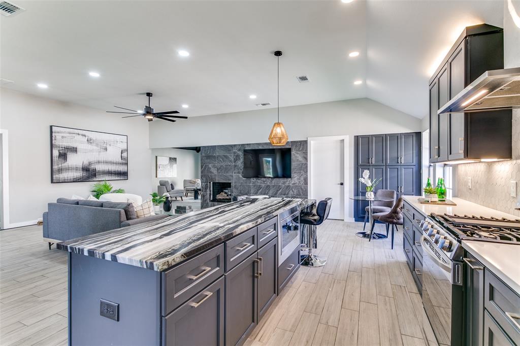 3913 Bobbin Lane Addison, TX 75001 - Photo 23 of 23 Kitchen featuring stainless steel appliances, open floor plan, light stone countertops, tasteful backsplash, and lofted ceiling