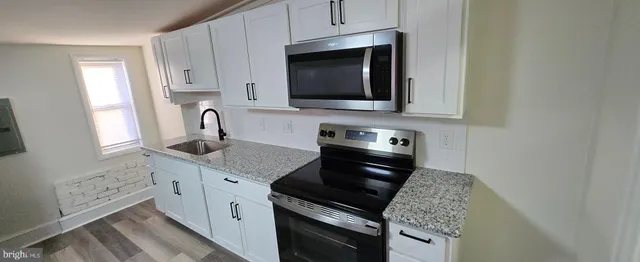 a kitchen with stainless steel appliances granite countertop a stove microwave and sink