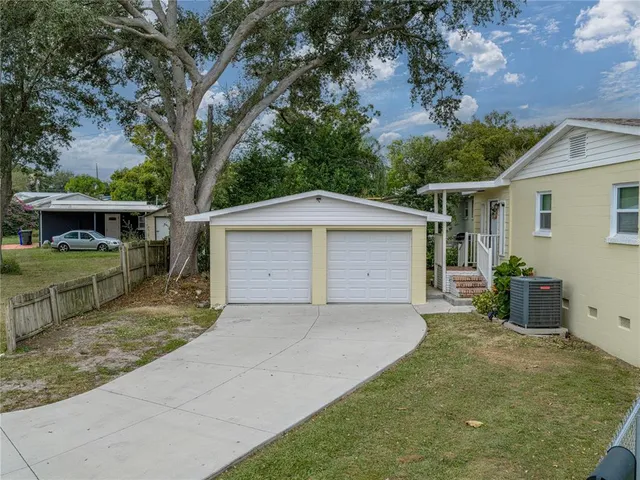 a front view of house with yard and trees in the background