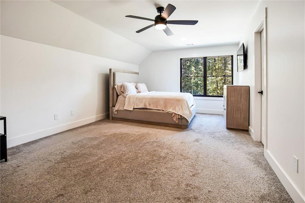 100 Ridge Way Forsyth, GA 31029 - Photo 48 of 99 a spacious bedroom with a bed and a large window