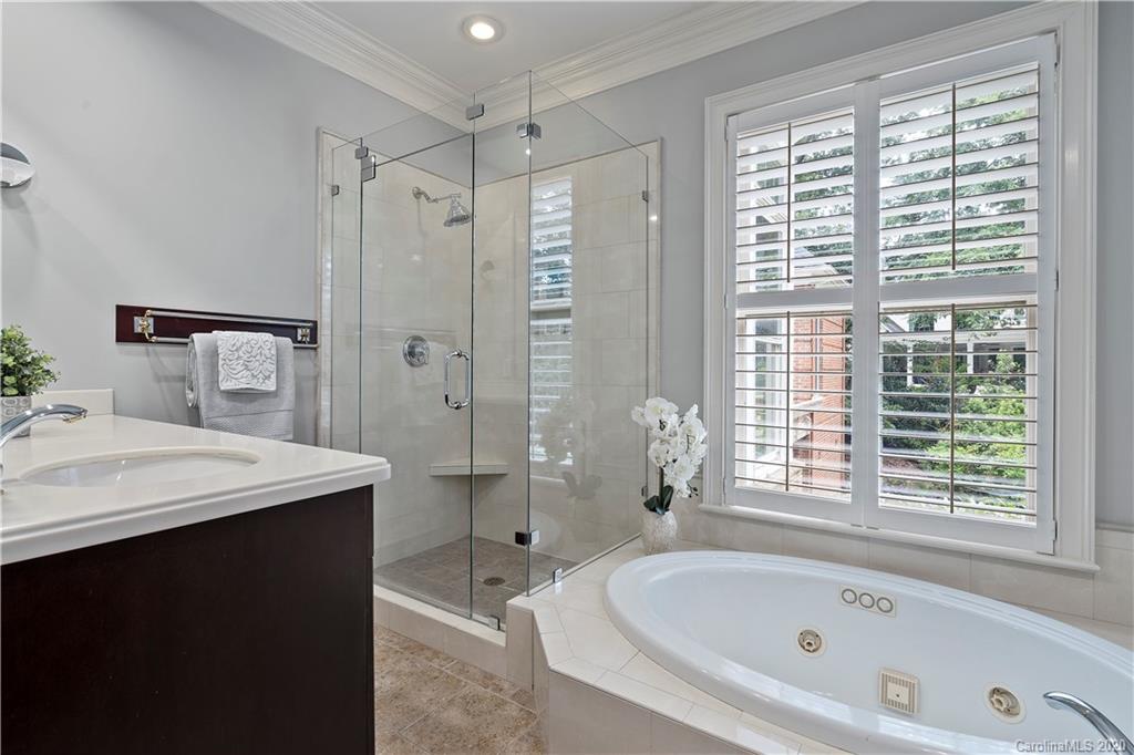 5321 Colony Road Charlotte, NC 28226 - Photo 20 of 29 a bathroom with a bathtub a sink a window and a shower