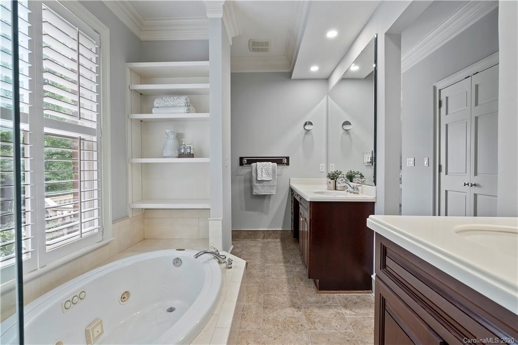 5321 Colony Road Charlotte, NC 28226 - Photo 21 of 29 a bathroom with a bathtub a sink and a large mirror