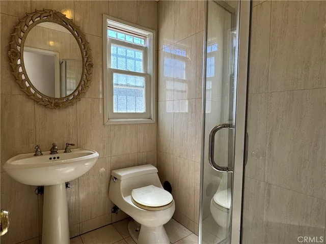 a bathroom with a sink a toilet and a mirror