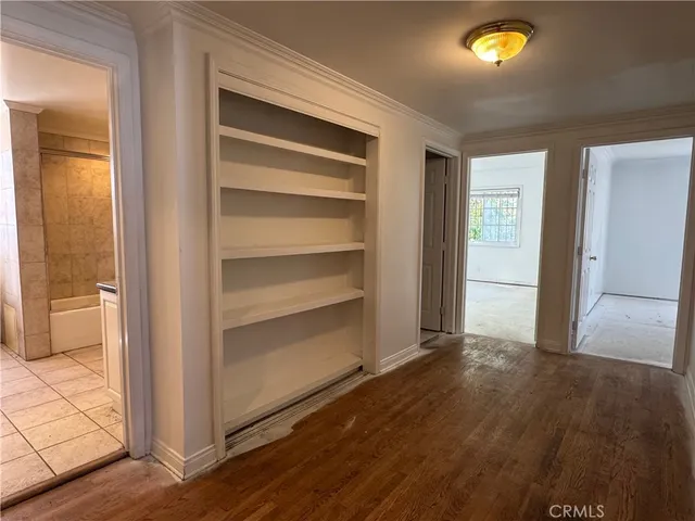 a view of empty room with wooden floor