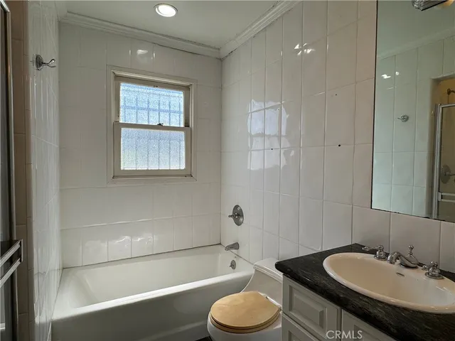 a bathroom with a granite countertop sink toilet a mirror and shower