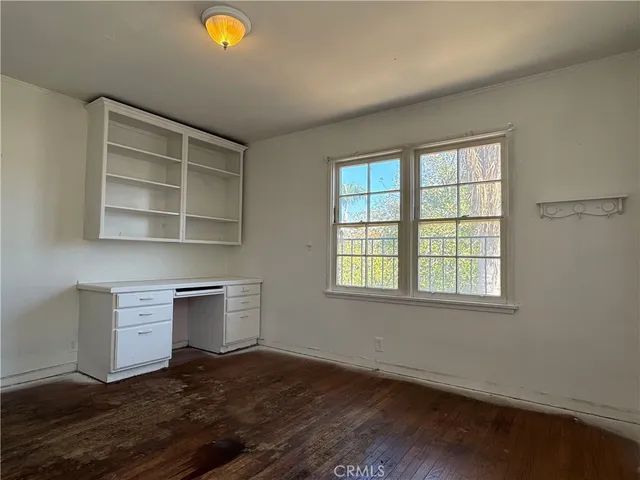 an empty room with windows and cabinet