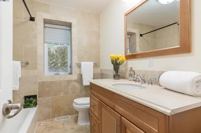a bathroom with a sink toilet a mirror and shower