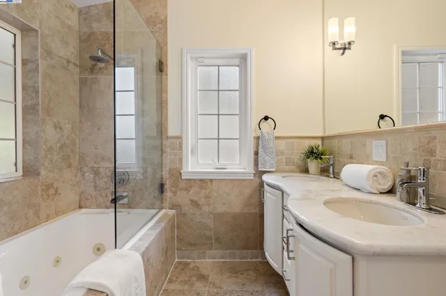 a bathroom with a granite countertop sink mirror and bathtub