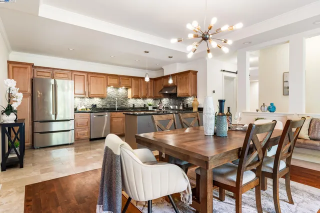 a dining room with kitchen island furniture a chandelier and kitchen view