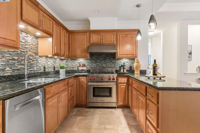 a kitchen with stainless steel appliances granite countertop a stove sink and cabinets