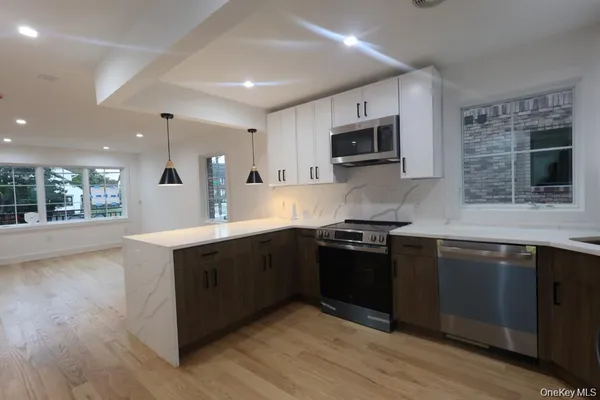 a kitchen with stainless steel appliances granite countertop a stove a sink and a microwave