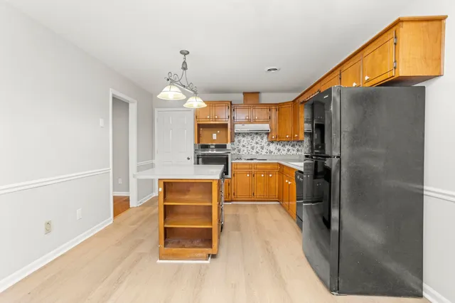 a kitchen with stainless steel appliances granite countertop a refrigerator a oven and a sink with granite countertops