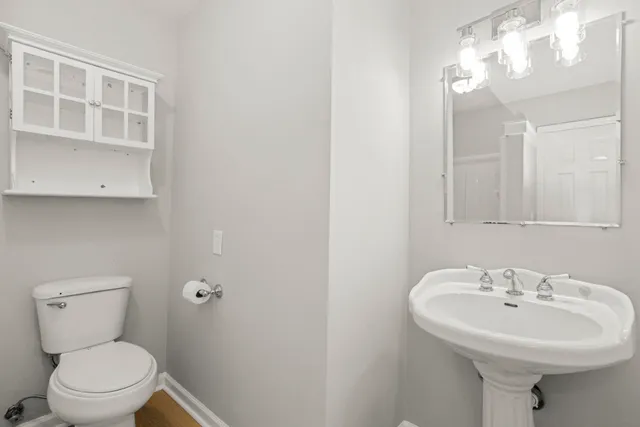 a bathroom with a sink a toilet and mirror