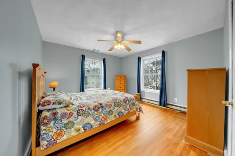 a bedroom with a bed and dresser with mirror