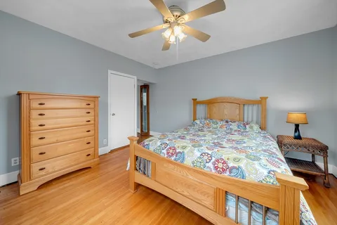 a bedroom with a bed and a chandelier fan