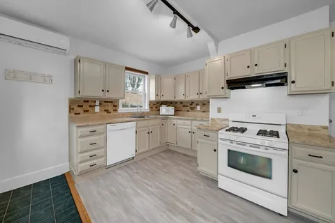 a kitchen with white cabinets sink and white appliances