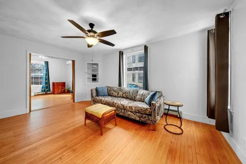 a living room with furniture and a wooden floor