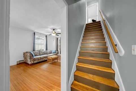 a living room with furniture and stairs