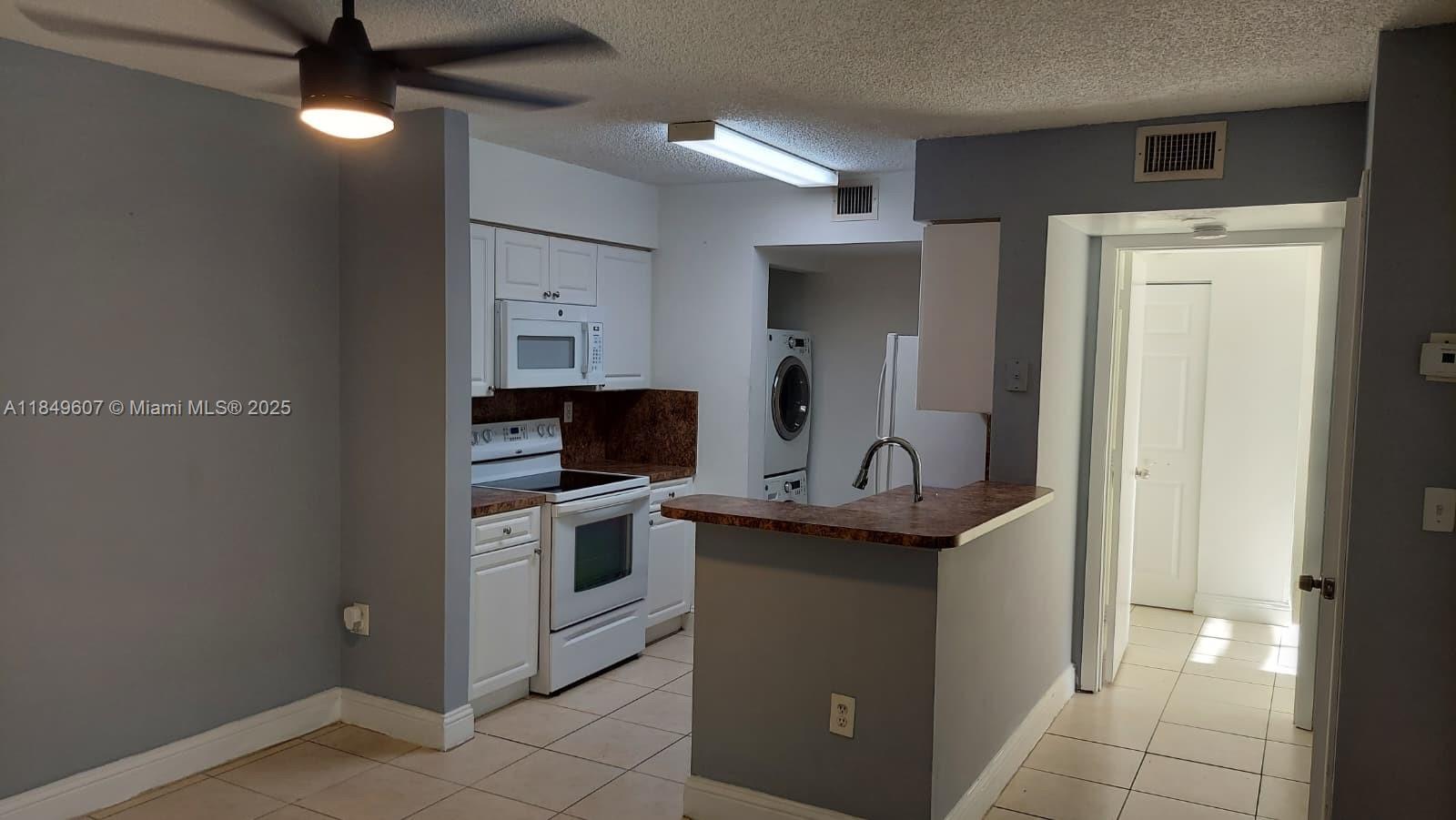 15231 Southwest 80th Street, Unit 209 Miami, FL 33193 - Photo 3 of 21 a kitchen with stainless steel appliances granite countertop a stove a sink and a refrigerator