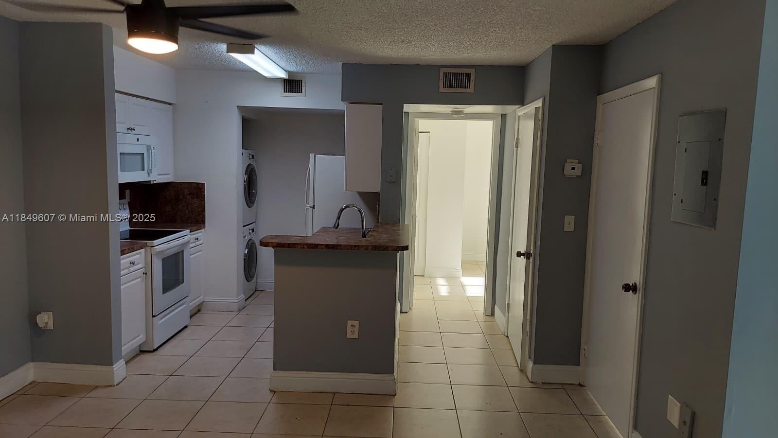 15231 Southwest 80th Street, Unit 209 Miami, FL 33193 - Photo 4 of 21 a kitchen with a refrigerator and a stove top oven