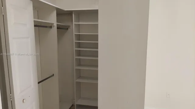 a view of walk in closet with empty racks