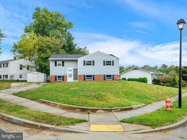 a view of a big house with a big yard plants and large trees