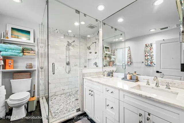 a bathroom with a sink a toilet and shower