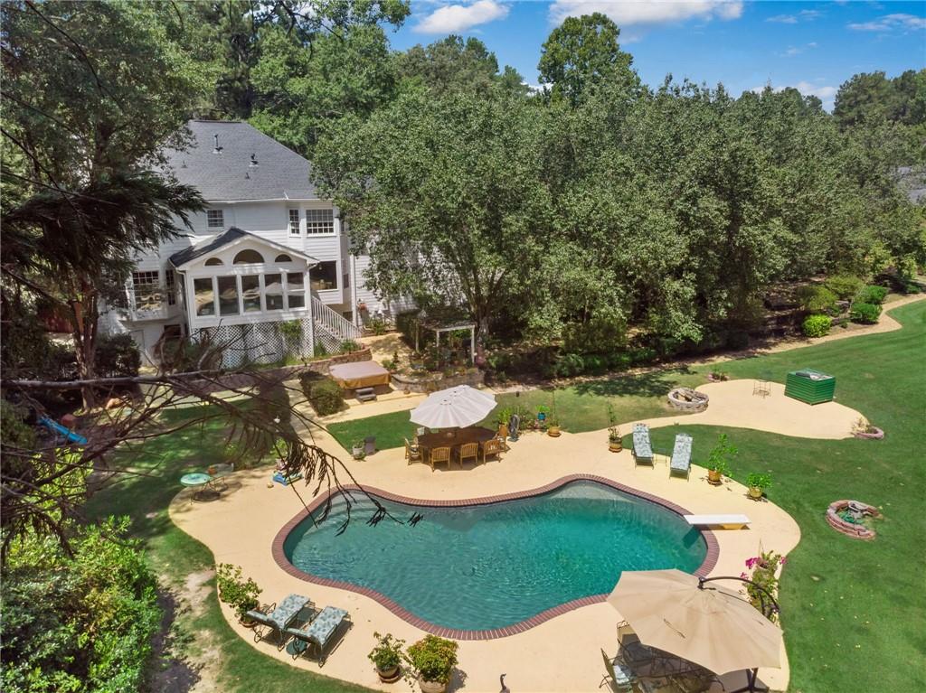 an aerial view of a house with swimming pool and a yard