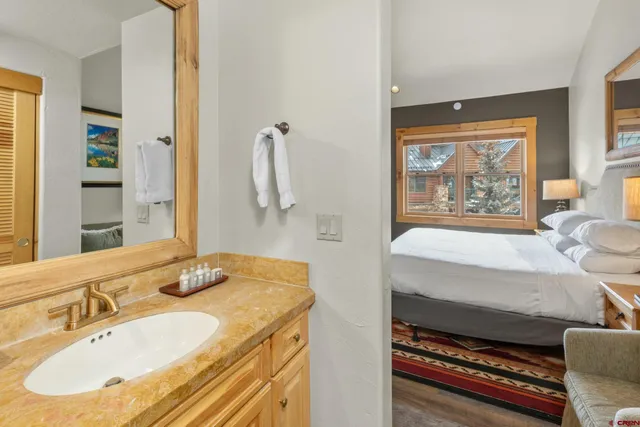 a spacious bathroom with a granite countertop sink and a mirror