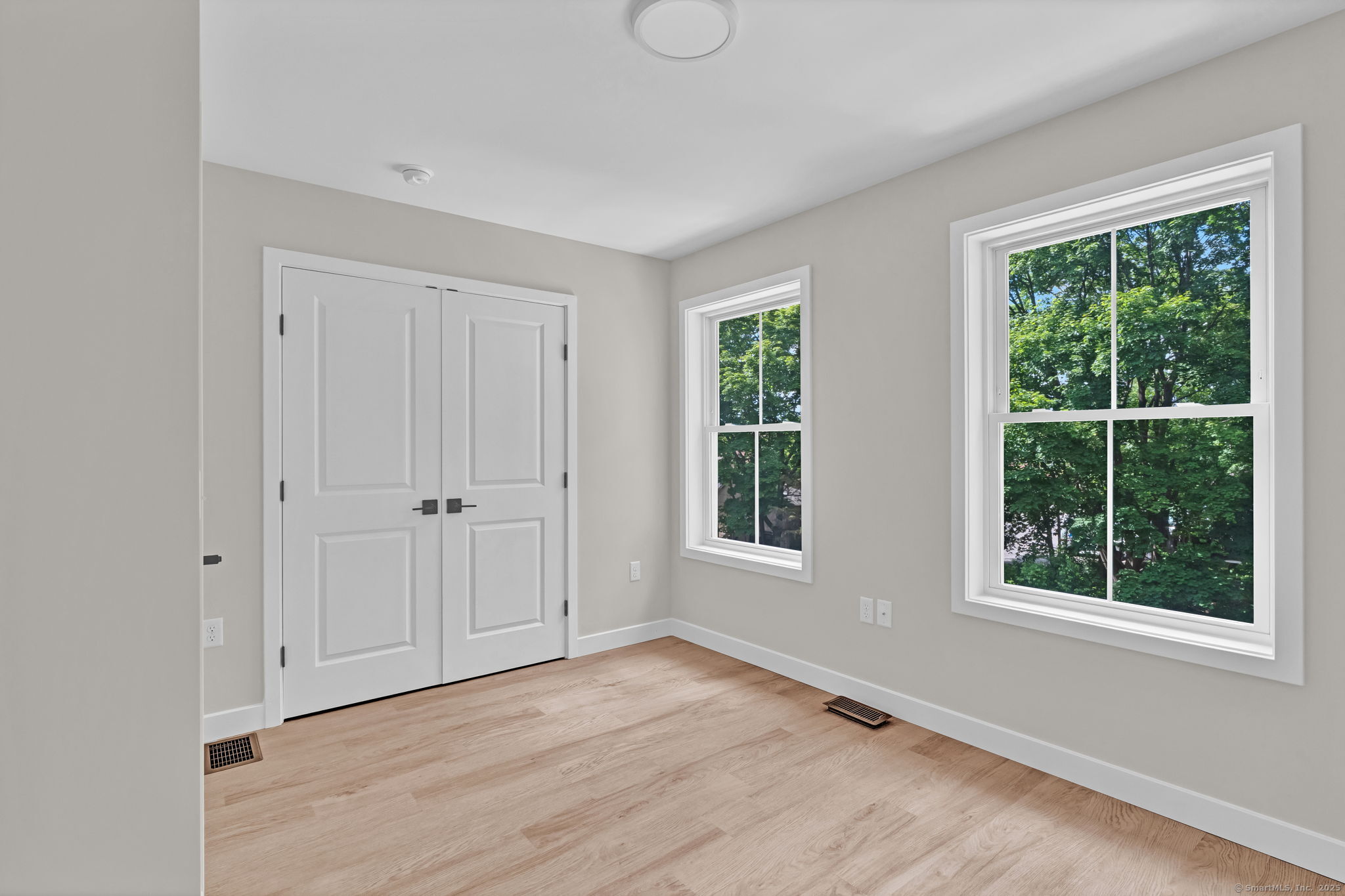 70 Whiting Street, Unit D Plainville, CT 06062 - Photo 16 of 26 a view of an empty room with wooden floor and windows