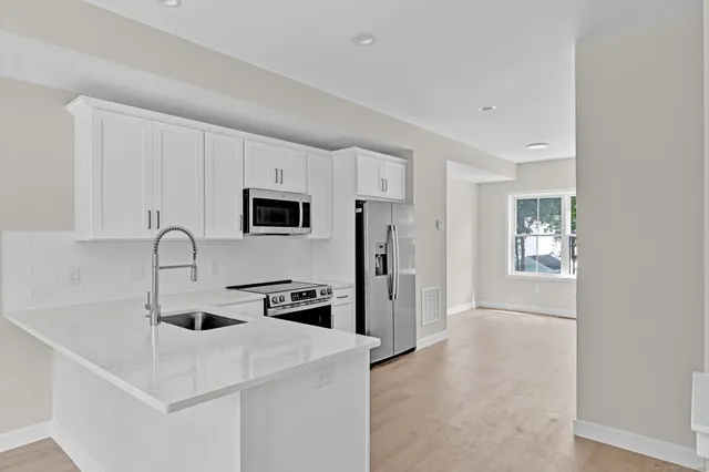 a kitchen with stainless steel appliances a microwave a sink and a refrigerator