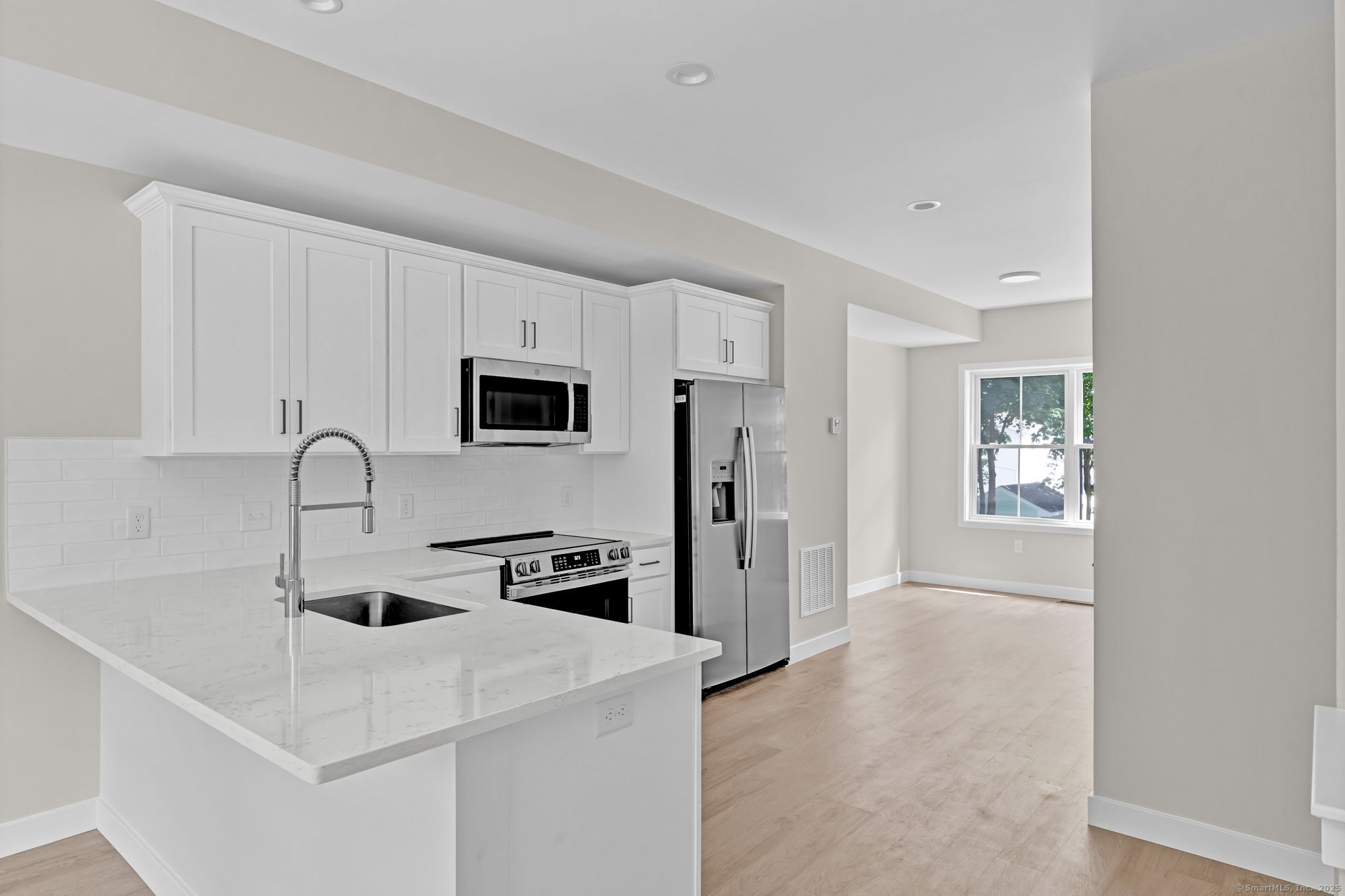 70 Whiting Street, Unit D Plainville, CT 06062 - Photo 5 of 26 a kitchen with stainless steel appliances a microwave a sink and a refrigerator