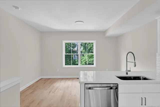 a kitchen with a sink a window and cabinets