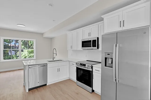 a kitchen with white cabinets and stainless steel appliances
