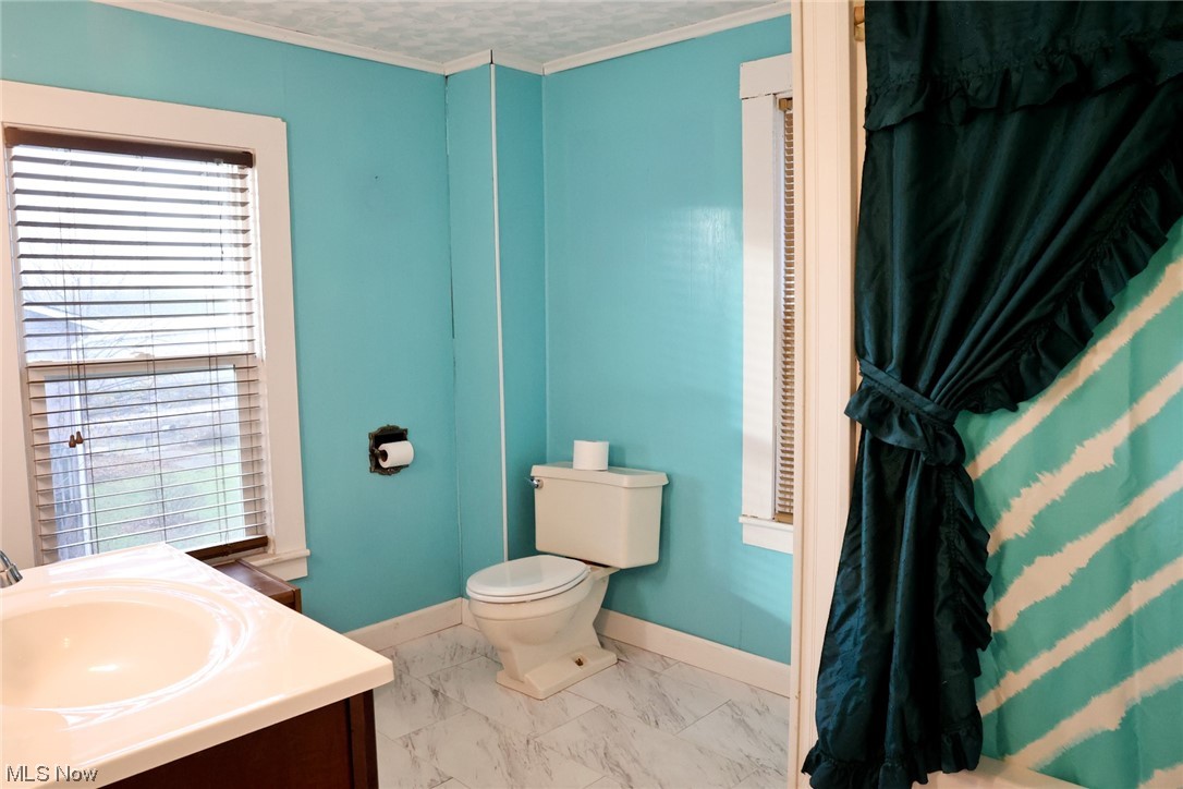 1309 Krumroy Road Akron, OH 44306 - Photo 15 of 30 Bathroom featuring crown molding, vanity, tile flooring, and toilet