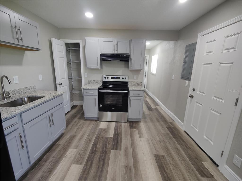 6804 Beth Road, Unit A Orlando, FL 32824 - Photo 2 of 14 a kitchen with stainless steel appliances a refrigerator sink and wooden floor