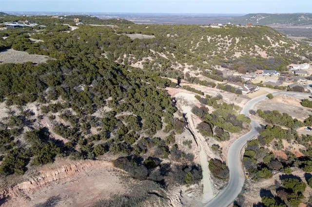 an aerial view of house with yard and mountain view in back