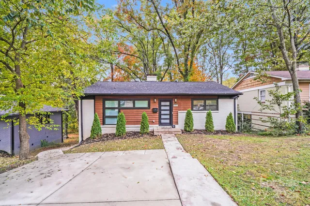 a front view of a house with a garden and yard
