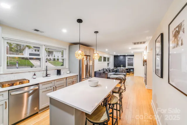 a large kitchen with kitchen island a large island a sink stainless steel appliances and cabinets