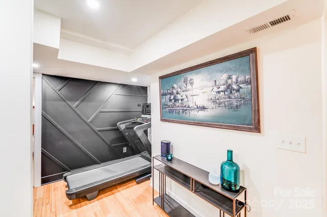 a room with gym equipment and potted plant