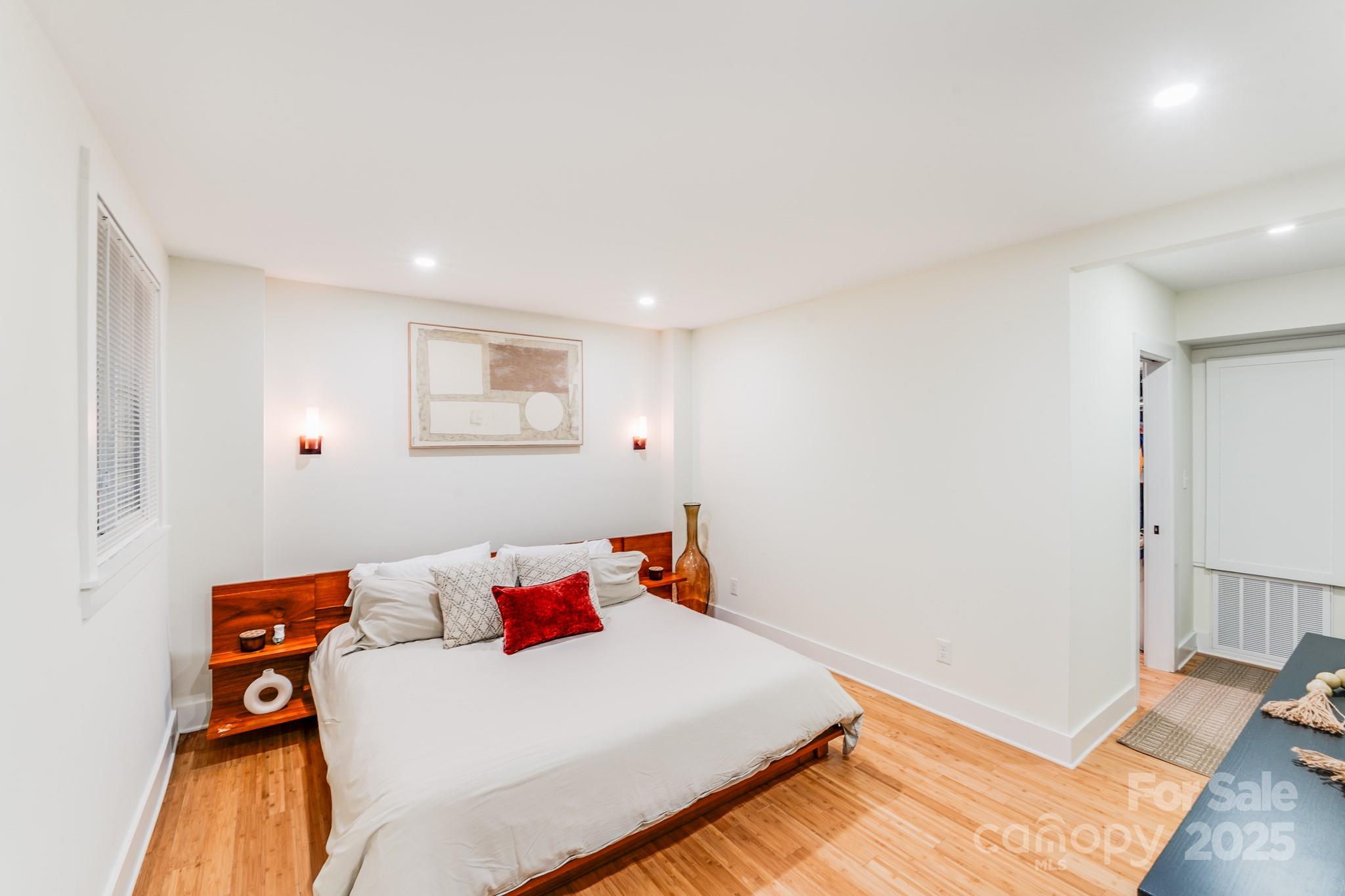 4910 Valley Stream Road Charlotte, NC 28209 - Photo 27 of 35 a bedroom with a bed and wooden floor