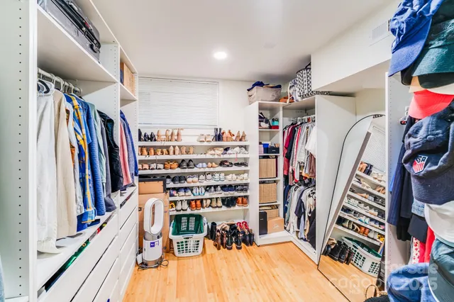 a view of walk in closet with clothes and shoes