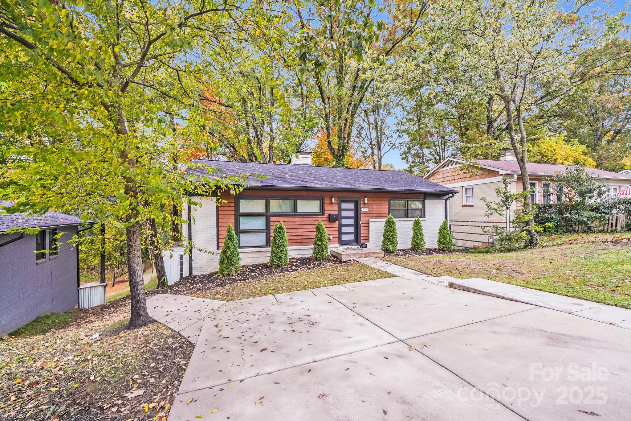 4910 Valley Stream Road Charlotte, NC 28209 - Photo 3 of 35 a front view of a house with a yard and trees