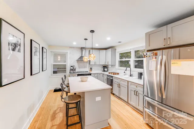a kitchen with stainless steel appliances a refrigerator sink and cabinets