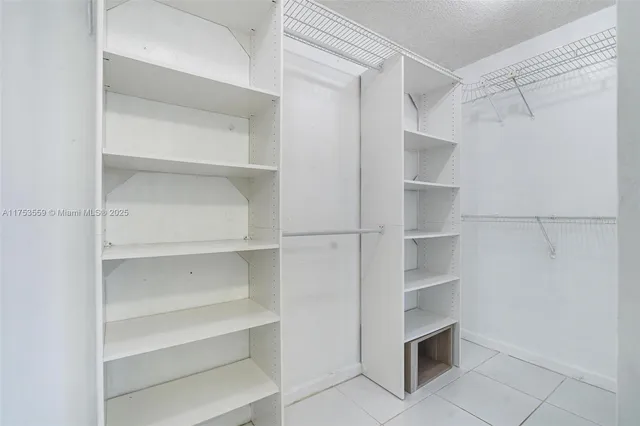 a view of walk in closet with empty racks