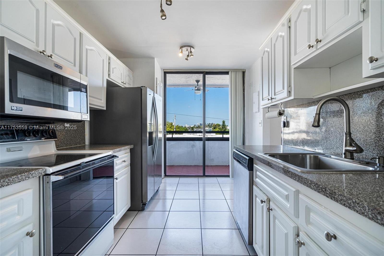 7300 Wayne Avenue, Unit 317 Miami Beach, FL 33141 - Photo 8 of 26 a kitchen with stainless steel appliances granite countertop a sink stove and refrigerator